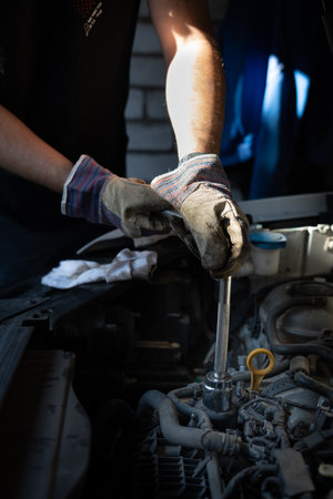 The mechanic repairs the car under the hoodの写真素材