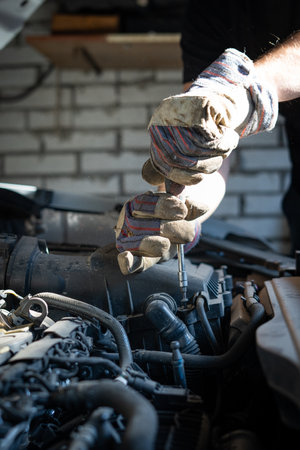 The mechanic repairs the car under the hoodの写真素材