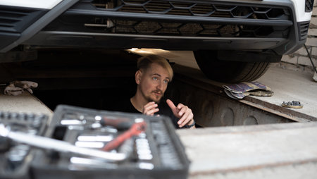 The mechanic services the car under the carの写真素材