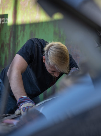 The mechanic repairs the car under the hoodの写真素材