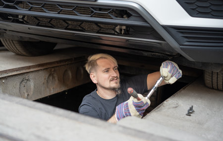 The mechanic services the car under the carの写真素材