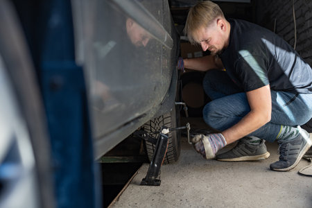 Mechanic replaces a wheel on a carの写真素材
