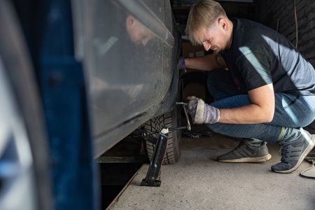 Mechanic replaces a wheel on a carの写真素材