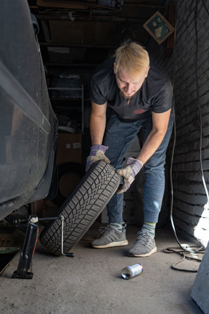 Mechanic replaces a wheel on a carの写真素材