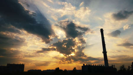 Boiler room chimney on the background of beautiful clouds and sunlightの写真素材