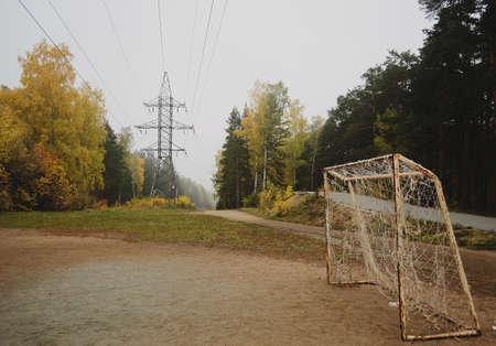 Football goal and power line in autumn forest