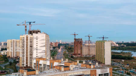 New buildings and residential buildings and cranes and evening sky, city panoramaの写真素材