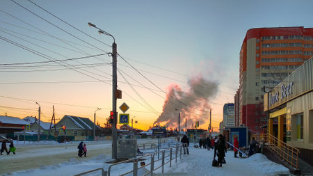 Chelyabinsk Russia - December 27, 2021. Salzman street. Winter life of a provincial small town against the backdrop of sunset and smoke from a thermal power plantのeditorial素材