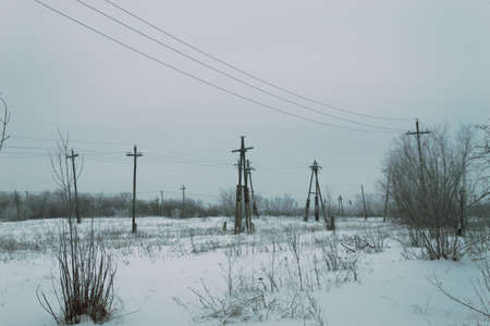 Old power lines in a winter field in the Russian outbackの写真素材