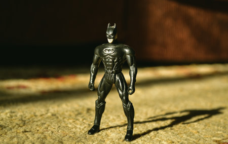 Kopeysk, Russia - August 10, 2021. Batman toy stands on a carpet and is illuminated by sunlight