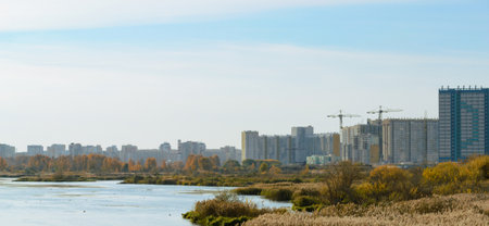 Panorama with river and nature and residential high-rise buildings in the distanceの写真素材