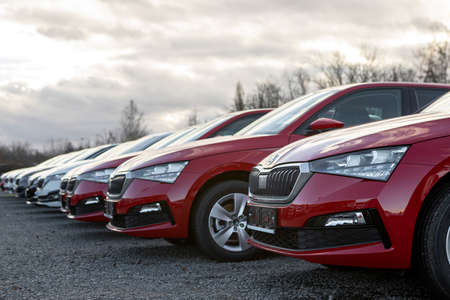PRAGUE, CZECHIA - JANUARY 3, 2022: Group of 4 new red Å koda Scala cars waiting for customer on...