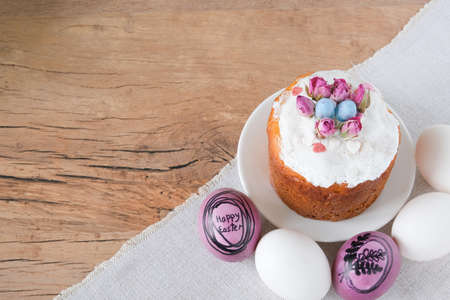 An Easter bun with colorful eggs is on the table. Space for your text. The idea of congratulating on...