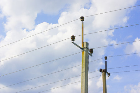 Electric poles with wires against the sky with clouds. The idea of providing electricity to the...