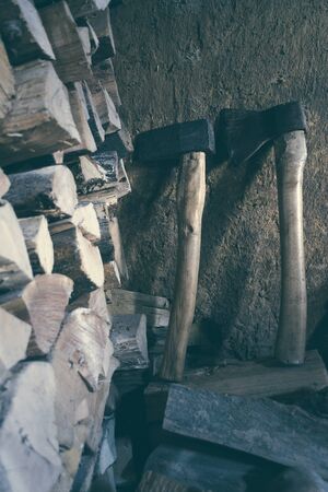 The old ax in a shed on the background of the mud wall