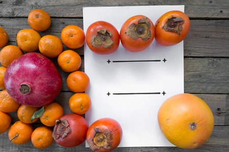 tangerines persimmon grapefruit with a sheet of paperの写真素材