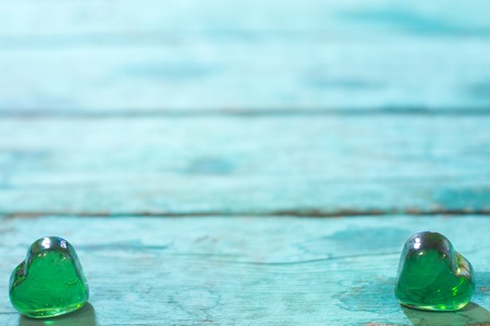Green glass heart on a wooden tableの写真素材