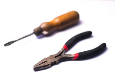 Old screwdriver and pliers on a white.の写真素材