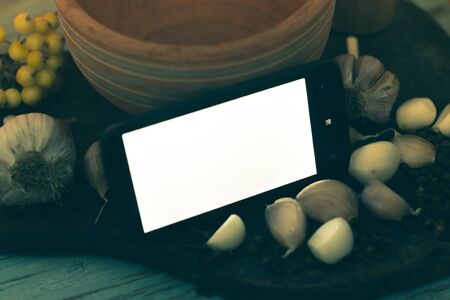 Smartphone on a wooden background with spices.の写真素材
