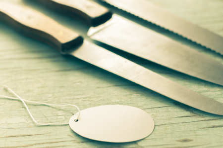 Kitchen knives sat on a wooden background.の写真素材