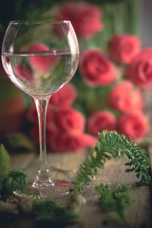 A glass of water on the flowers and plants againstの写真素材