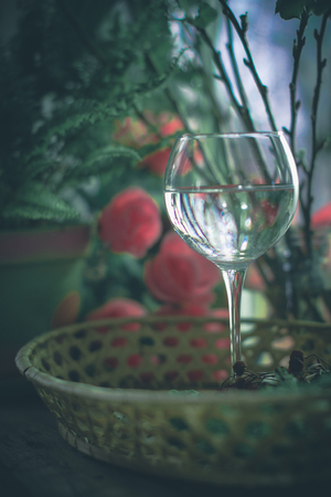 A glass of water on the flowers and plants againstの写真素材