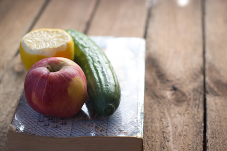 Fruits and vegetables near the old bookの写真素材