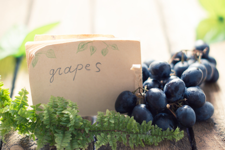 Grapes on a wooden table with a tagの写真素材