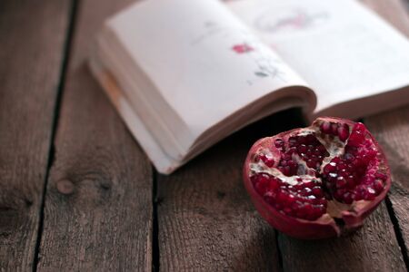 Garnet fruit near the bookの写真素材