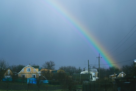 Spring rainbow over the villageの写真素材