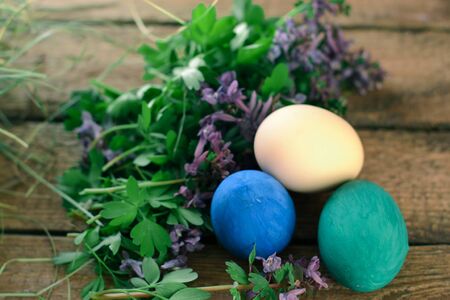 Multi-colored Easter eggs on a wooden background in the nestの写真素材