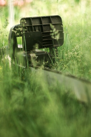 Power saw on green grass on blur backgroundの写真素材