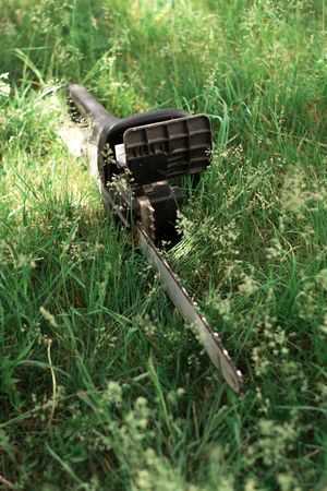 Power saw on green grass on blur background