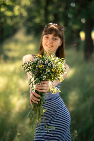 Girl with a bouquet of wildflowers on a sunny dayの写真素材
