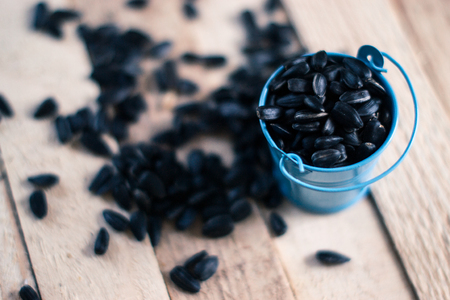 Sunflower seeds on a wooden board on a blurred backgroundの写真素材
