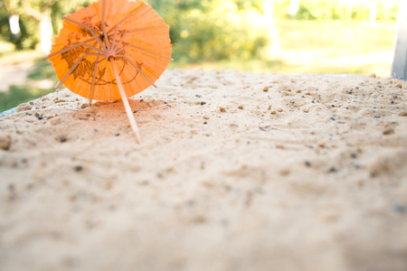 Umbrella for cocktails on a sandy summer backgroundの写真素材