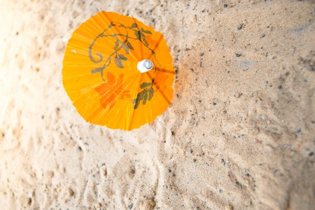 Umbrella for cocktails on a sandy summer backgroundの写真素材