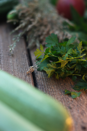 Fresh green parsley on an old wooden board with vegetablesの写真素材