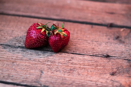 Ripe strawberries on a wooden old tableの写真素材