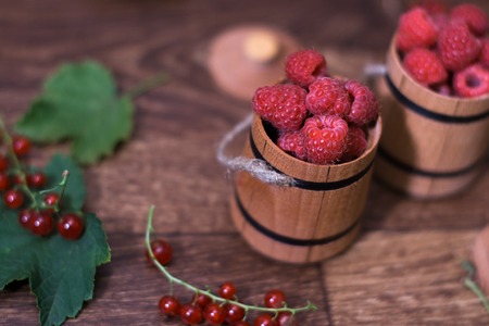 Raspberries in a wooden small barrel with a blurred backgroundの写真素材