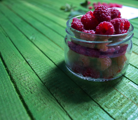Fresh ripe raspberries on green wooden boards