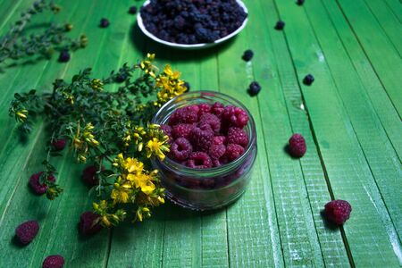 Berries raspberries and blackberries on a wooden background