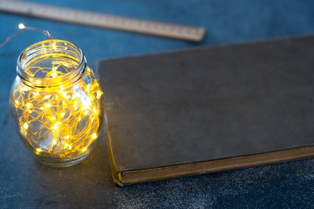 Dark background of an old book on a matte background with lightsの写真素材