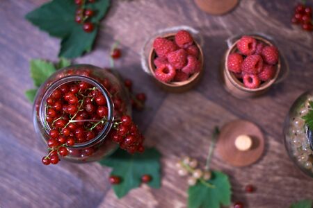 Berries of a currant in a glass jar on a wooden background