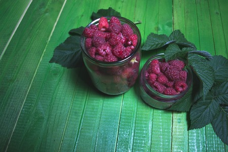 Fresh ripe raspberries on green wooden boards