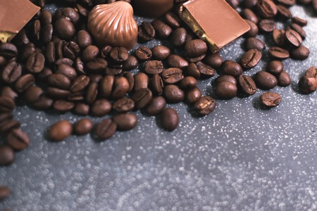 Coffee beans and tiles of dark chocolate on a dark matte backgroundの写真素材