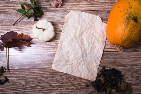 Autumn still life: pumpkin and autumn leaves on a wooden background