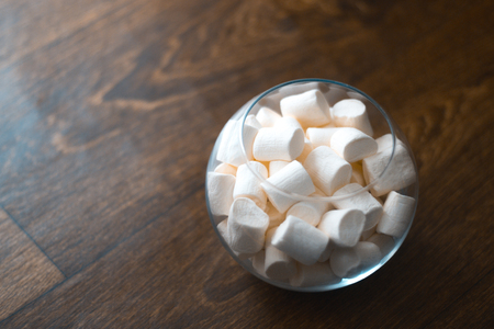 Marshmallow in a glass bowl on a wooden backgroundの写真素材