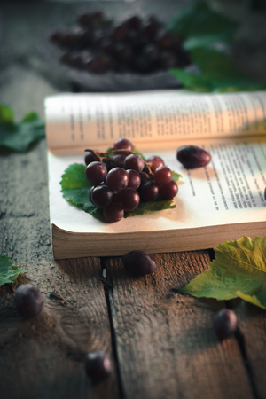Autumn still life: Grapes with a book on a wooden backgroundの写真素材