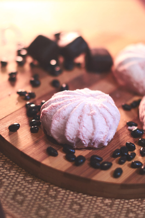 Marshmallow and other sweets on a wooden background still life